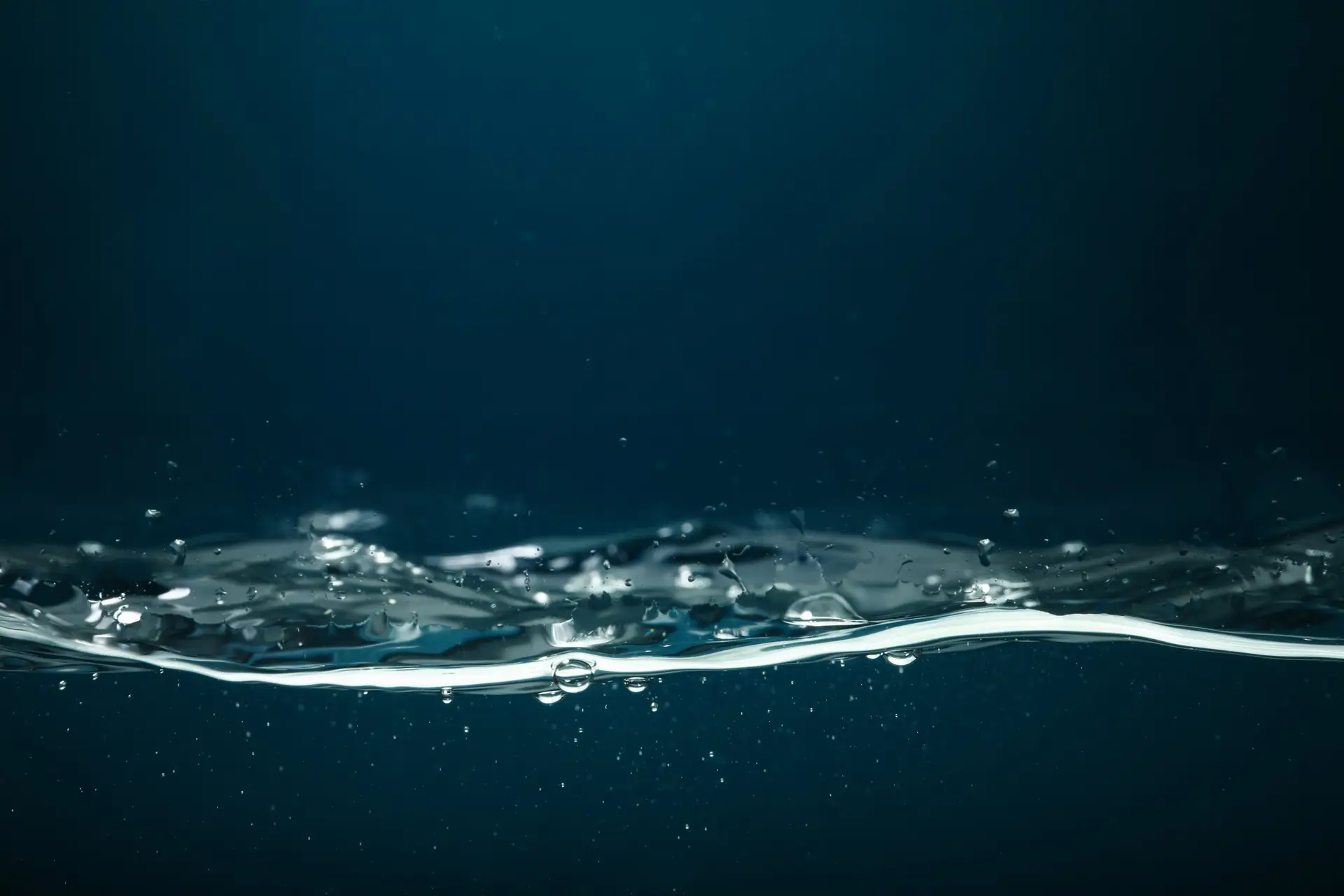 Klares Wasser mit Luftblasen vor dunkelblauem Hintergrund